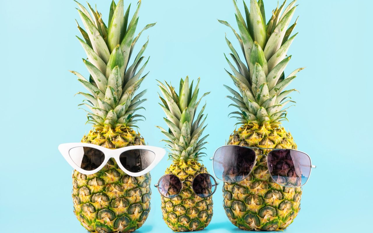 three pineapples with glasses in the form of a family of three on vacation. concept of summer travel to tropical countries